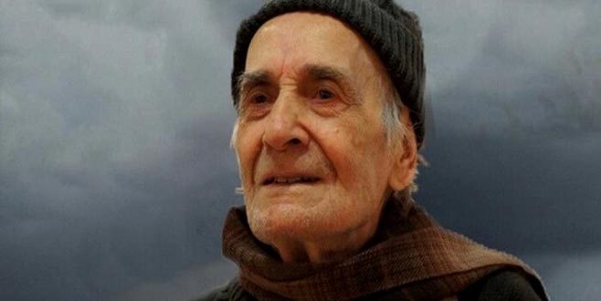 Ressam İbrahim Balaban Yatay dikdörtgen renkli fotoğrafta İbrahim Balaban, gri ve koyu mavi tonlardan oluşan bulutların olduğu fonun önünde duruyor. Hafif sağa dönmüş, omuz hizasında fotoğraflanmış.  Boynunda atkı, başında bere var. Balaban bu fotoğraf çekildiği sırada muhtemelen 70’lerinin sonunda.  Sol alta doğru bakıyor ve ağzı ön dişleri gözükecek biçimde hafif aralık.  Açık buğday tene sahip uzun zayıf bir yüzü ve geniş bir çenesi var. Kulağının ortasına kadar gelen favorileri beyaza yakın gri bir renkte. Ensesinden çok az olacak şekilde saçları gözüküyor. Sakalları en fazla bir gün önce traş edilmiş, henüz çıkmamış.  Alnı geniş ve açık. Kaşlarının arasında kırışıklıklar mevcut. Gözünün üst kısmını çevreleyen gür koyu gri kaşları var. Gözlerinin kenarlarında kırışıklık ve altında göz torbaları olan Balaban’ın gözleri siyah. Kirpikleri belli belirsiz. Burnu kemerli ve büyük. Sol omzu önde bir şekilde durduğu için, sol burun deliğini görebiliyoruz. Sol kulağının bir kısmı berenin içinde kalmış, büyük bir kulağı var. Kulak memesi geniş.  Burnundan dudak kenarlarına doğru derin kırışıklığı var. Balaban’ın dudakları neredeyse yok denilecek kadar ince. Hafif aralık bıraktığı ağzından ön dişleri gözüküyor. Hafif sararmış, öndişleri biraz çarpık. Atkının dolanmış olduğu boynunu çok az görebiliyoruz. Sarkmış bir gıdısı var.  Başını örten ince çizgili, siyah berenin tepesi kadraja girmemiş. Balaban, boynuna bir kere dolanmış kahverengi tonlarında enine ve boyuna önce çizgilerden oluşan bir atkıyla poz vermiş. Sol omzunun kadraja giren kısmından siyah ve yünlü bir kumaş olan kaşeden bir kaban giydiğini söyleyebiliriz