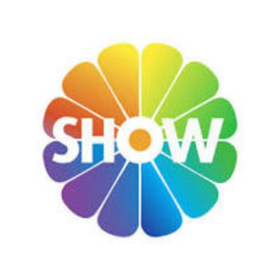 SHOW Beyaz zemin üzerinde, gökkuşağı renklerinde 12 adet yapraktan oluşan dairesel bir çiçek figürünün merkezine yerleştirilmiş beyaz, kalın harflerle yazılmış SHOW ibaresi.