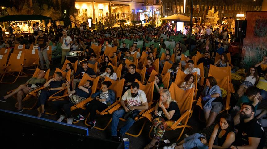 Sesli Betimleme ile Açık Havada Engelsiz Sinema Keyfi Yapıkredi Bomonti Ada'da çekilen fotoğrafta turuncu şezlonglarda oturan kalabalık bir grubun film izlediği gece vakti açık hava sineması etkinliği.